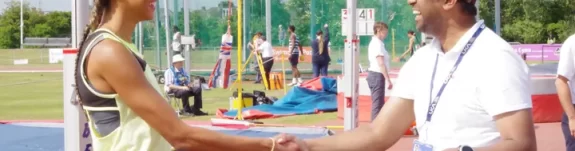 Male official shaking hands with a female athlete