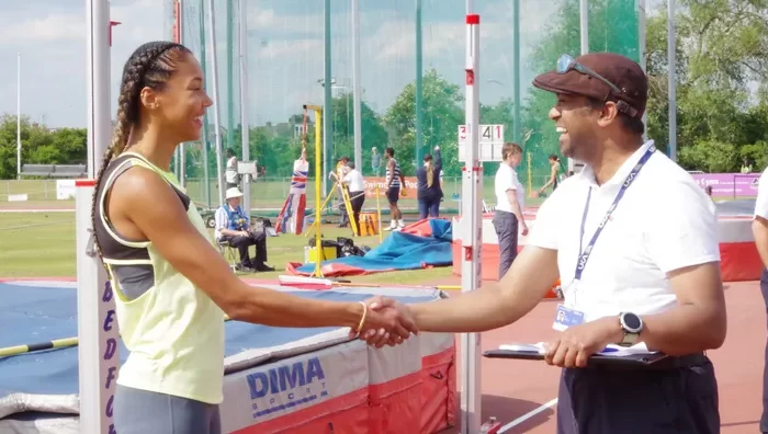 Male official shaking hands with a female athlete